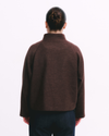 Person wearing a brown jacket on a white background