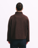 Person wearing a brown jacket on a white background