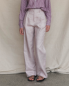 Model wearing a striped shirt and light-pink coloured pants against a plain background