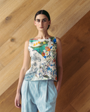 Model wears spliced patchwork top against wooden background