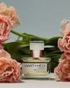 Pardis perfume bottle sat in front of some pink and green florals 