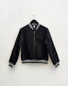 Black bomber jacket with white trim on a hanger against a white background