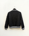 Black lace jacket with on a hanger against a white background