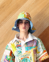 Person wearing a colorful patterned hat against a wooden background