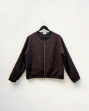Burgundy jacket on a hanger against a white background