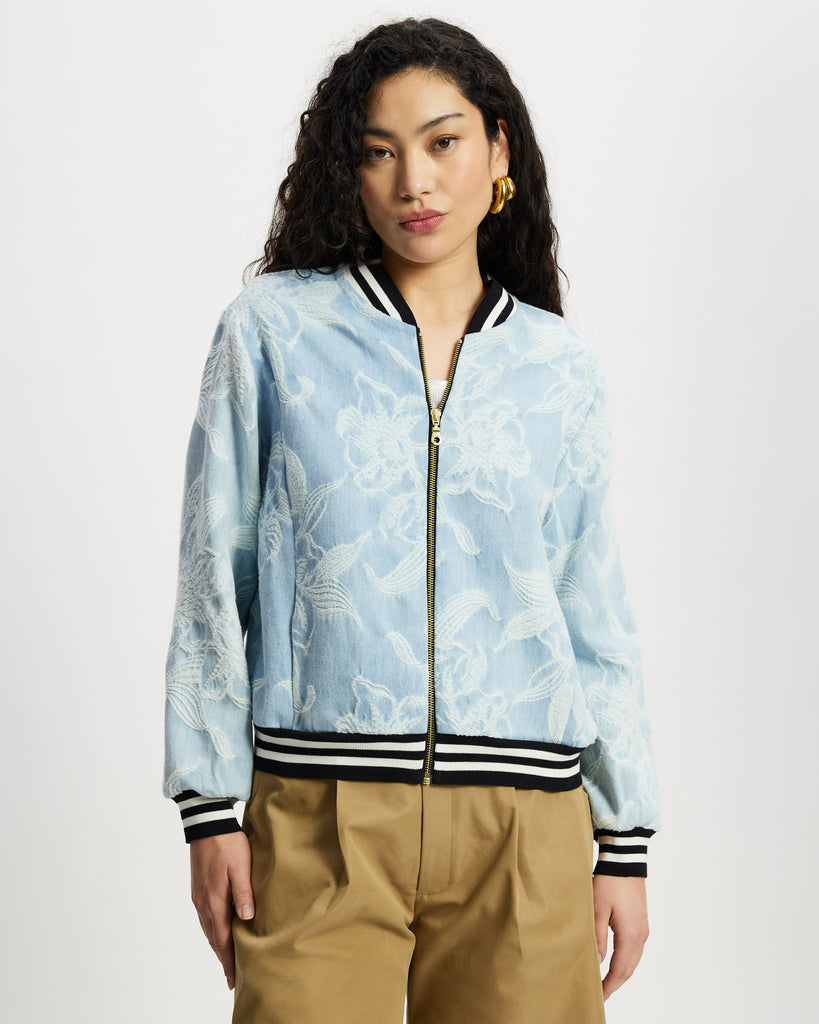 Model wears aviator in light denim with white floral large scale pattern.