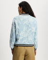 Model wears aviator in light denim with white floral large scale pattern.
