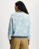 Model wears aviator in light denim with white floral large scale pattern.