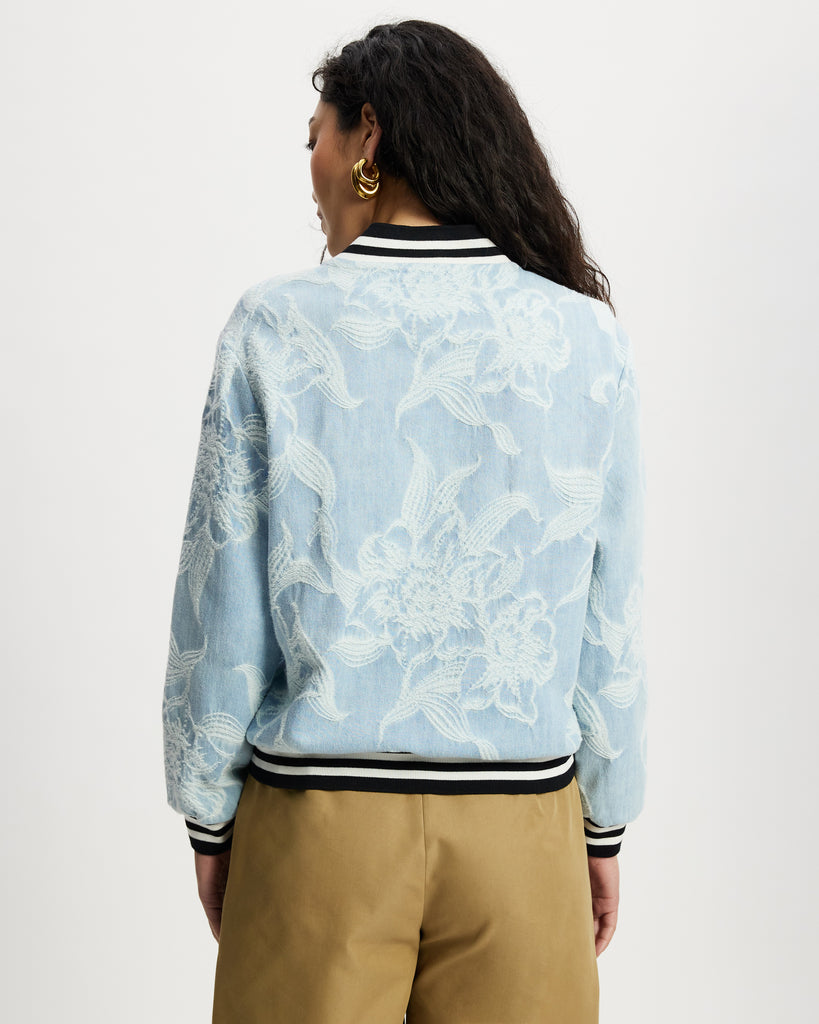 Model wears aviator in light denim with white floral large scale pattern.