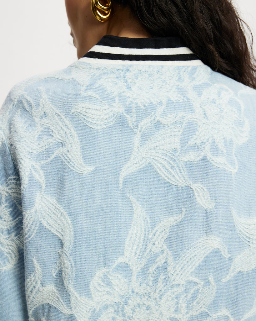 Model wears aviator in light denim with white floral large scale pattern.