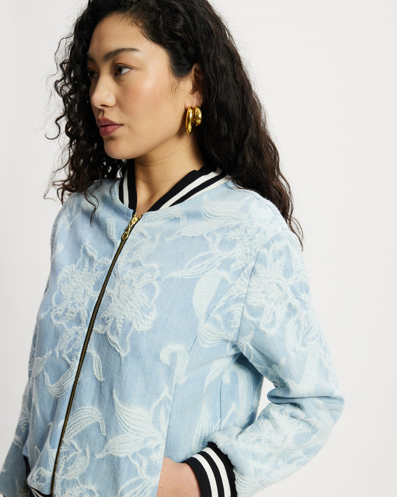 Model wears aviator in light denim with white floral large scale pattern.