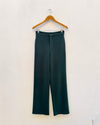 Bottle Green Wide Leg Pants hanging on white wall