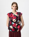 Model wearing a cowl draped top with a burgundy floral print. 