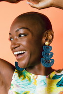 Model wears Casa Bonita Handwoven Iraca Palm Blue Tiered Earrings