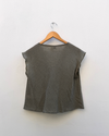 Checked Cowl Draped Top hanging against white wall.