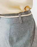 Gray pants with a white belt on a neutral background