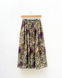 Floral patterned skirt on a hanger against a white background