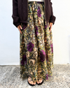 Person wearing floral-patterned pants with a plain background