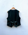 Dark green vest on a wooden hanger against a white background