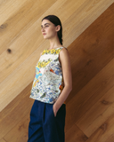 Model wears spliced patchwork top against wooden background