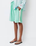 Model wears teal shorts with light yellow racing stripe down the side