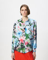 model wearing a brightly coloured floral shirt with an orange skirt