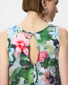 A close-up back view of a woman wearing a sleeveless top with a colorful floral watercolor print and a keyhole cutout at the back.