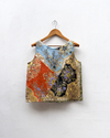 Decorative top with floral and geometric patterns on a wooden hanger against a white background