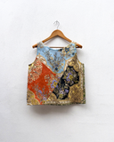 Decorative top with floral and geometric patterns on a wooden hanger against a white background