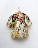 Colorful patterned shirt on a hanger against a white background