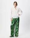 Model wearing a white broderie blouse with green patterned pants