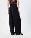 model wearing the black pleated pants, photo taken from the back
