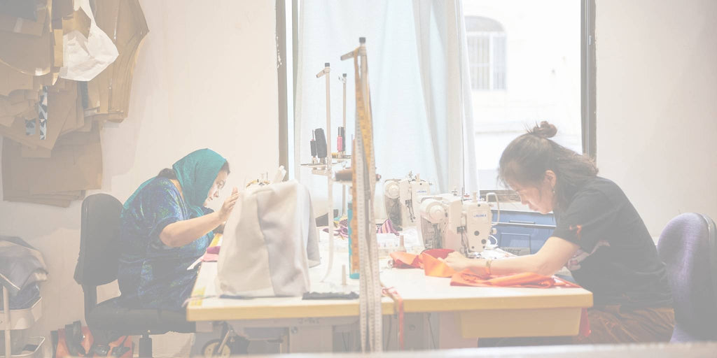 two women from refugee and new migrant backgrounds sewing in The Social Outfit's Newtown-based workroom manufacturing ethically made garments for third party clients in Sydney, Australia.