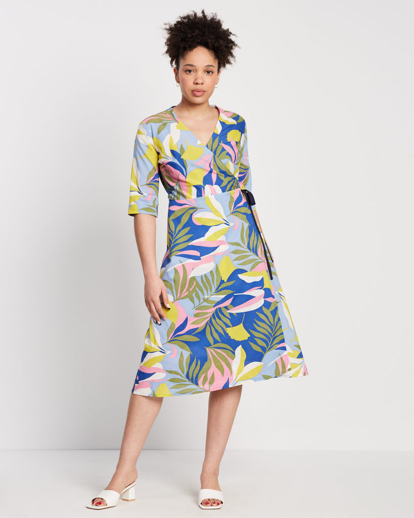 colourful floral wrap dress with navy tie and blue, yellow pink and green print worn with white sandals