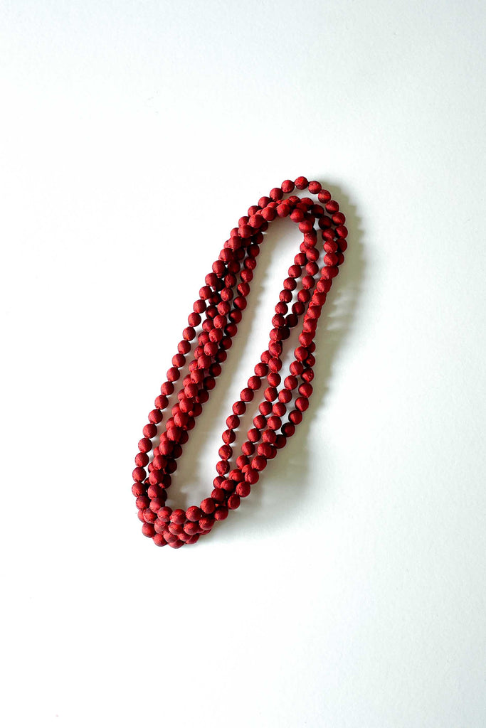 garnet red silk long strand necklace from tabitha foundation against white backdrop