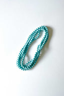 light blue aqua silk long strand necklace by tabitha cambodia against a white backdrop