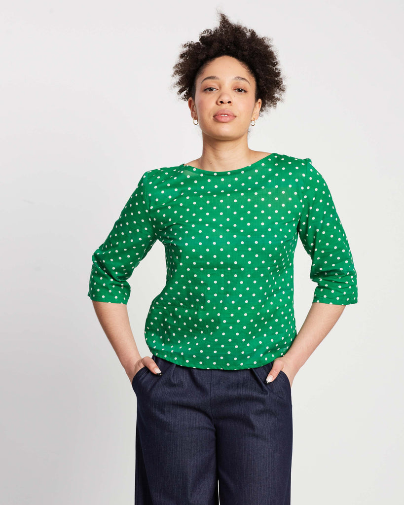 woman wearing green polka dot top with three-quarter sleeves and blue indigo culottes