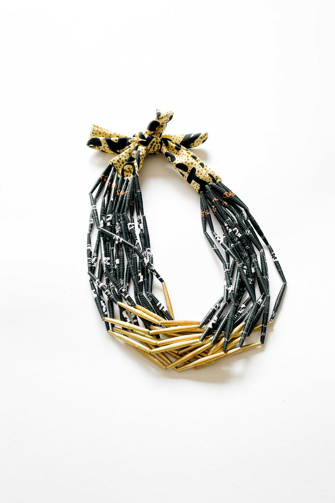 black and gold paper beaded necklace with fabric tie on white backdrop
