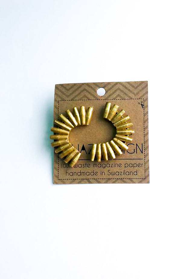 gold Quazi Design Earrings on cardboard against a white backdrop