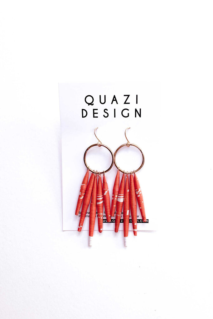 pair of orange circle drop paper earrings by quazi design against white backdrop
