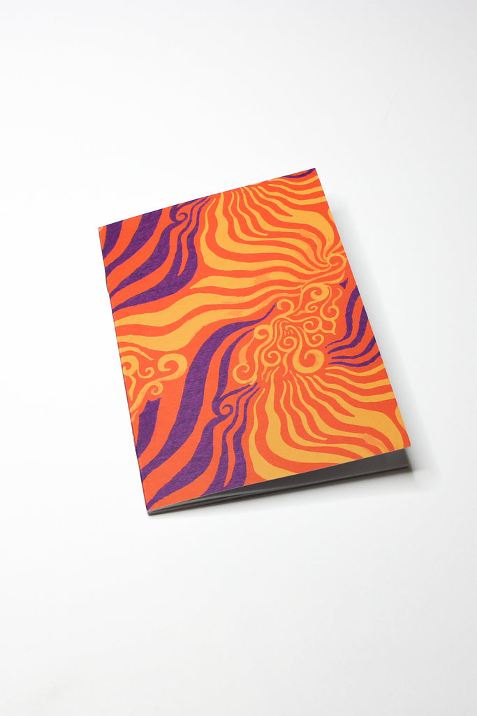 orange and purple printed notebook laying flat on white background